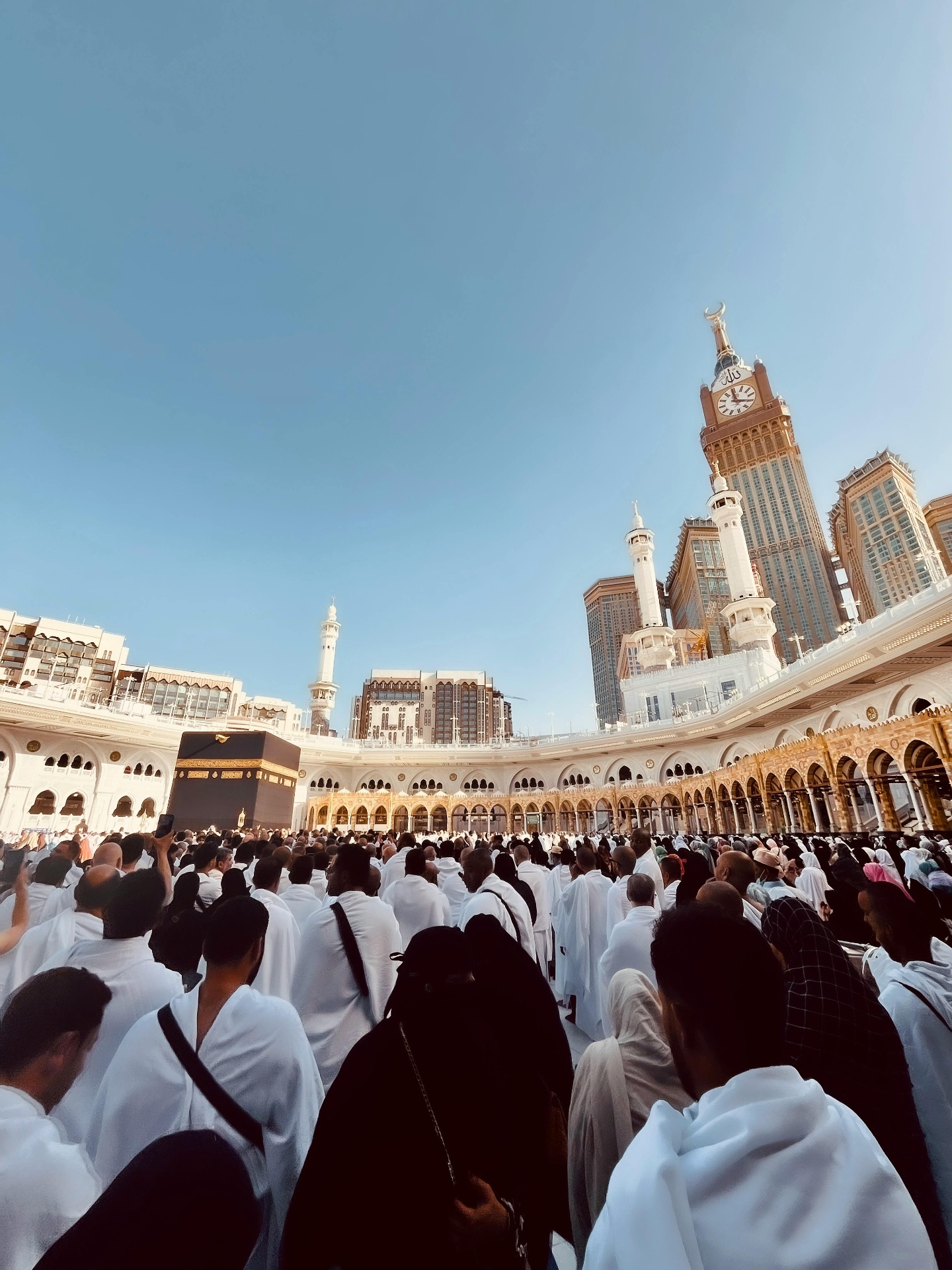 Pilgrims in Ihram gathered at Masjid al-Haram with the Clock Tower behind